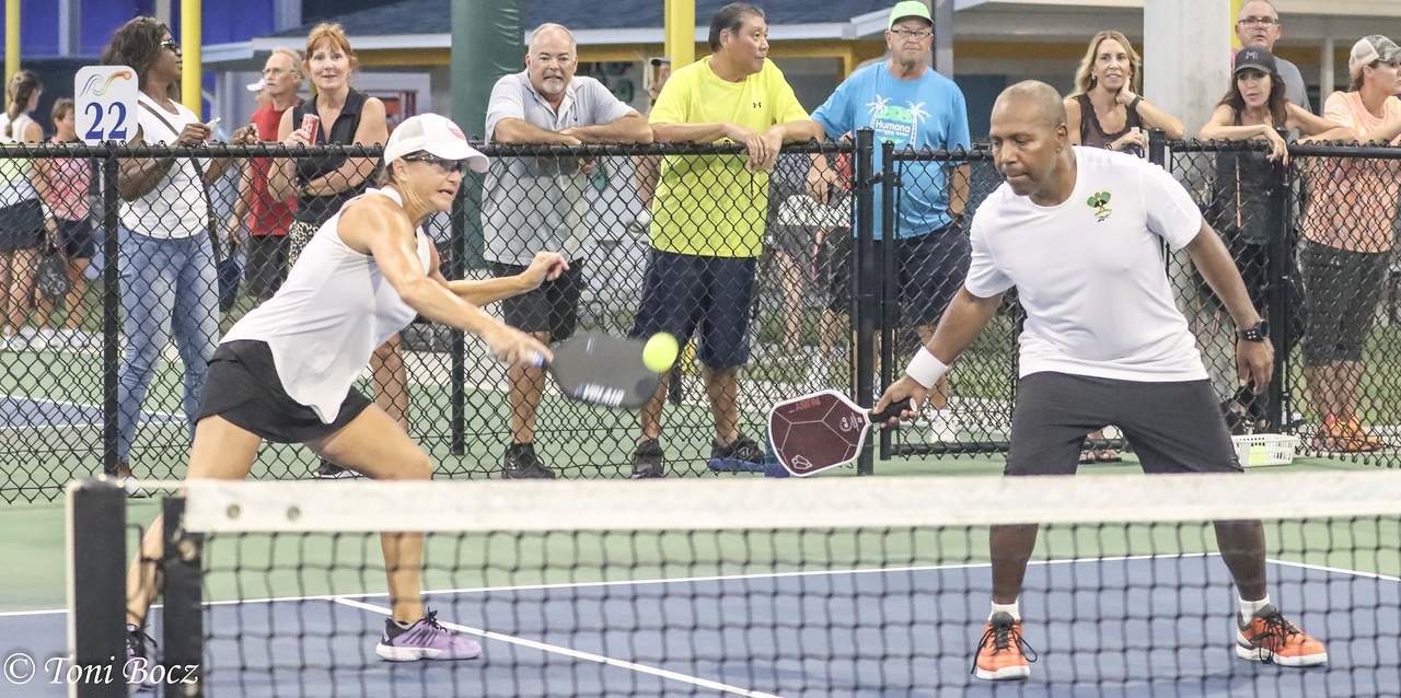 Mixed doubles on outside court with spectators